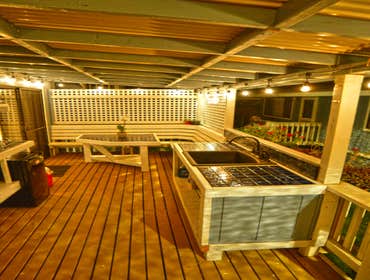 Outdoor Kitchen Added a roof, shelves, counters, sink, and a table to match existing benches and railing. This turned a master bedroom into a functiona