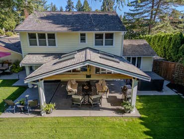 Hein Project This Issaquah, Washington custom outdoor living project features a gable-style patio cover with a skillion roof extension designed to prov