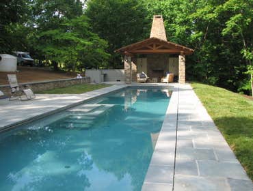 Infinity Edge swimming pool Charlottesville Infinity edge pool with colorized plaster, water feature, tanning shelf, seating benches w/ jets, beach ent