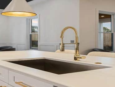 Kitchen island detail with brass pull-down faucet and quartz surface crafted by CJMC Build in 12 South, Nashville.