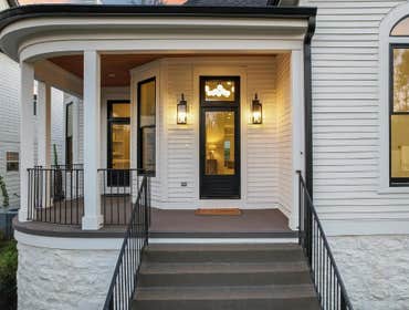 Restored curved front porch and new entry lighting maintaining the historic street presence by CJMC Build in 12 South, Nashville.