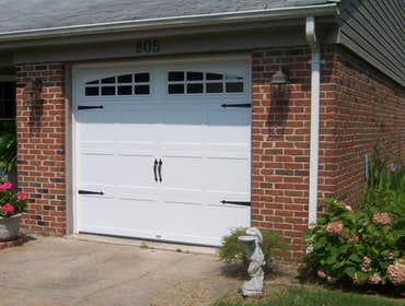 Carriage style doors First door (white with black hardware) is a stamped steel entry level door, second white painted custom door from Carriage House D