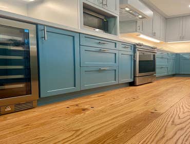 Interior Remodel Two tone kitchen cabinet with undercabinet lighting, Farmhouse sink. Extended Wood Flooring to Kitchen and finished to match. Replac