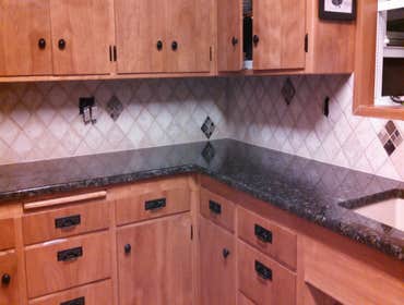 Auburn Backsplash Very French Country Side back splash. I like the ceramic mural placed above the stove top, it looks like a window view out onto a lan