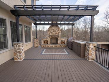 Photos by Iron Ridge Contracting LLC #1 Foretress steel framing on a custom stone and Deckorators deck with fire burning stove, kitchen with stainless 