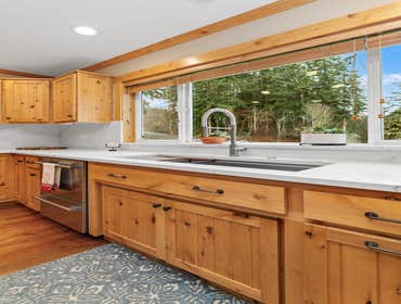 Angela & Dereck | Kitchen This kitchen remodel includes newly installed warm-toned hardwood flooring, elegant white quartz countertops with subtle vein