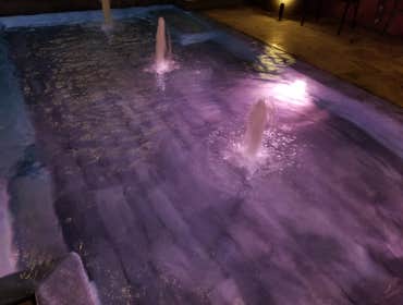 Custom Pools Wet edge pool in phoenix with sun shelf, splash pad and hardscape/landscape.