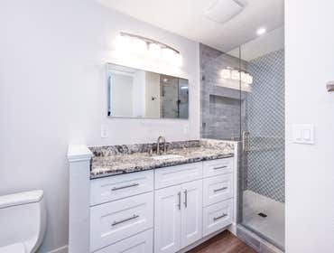Bathroom Remodel with Gray Tile & Granite Vanity in Sacramento, CA 95820 This bathroom renovation transformed a standard space into an elevated, spa-li
