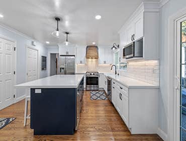 Stanford Kitchen and Bathroom Remodel We remodeled this kitchen to include a blue island, quartz countertop, wine fridge, farmhouse sink, undercabinet 