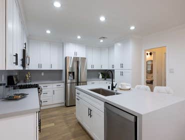Melvin Complete Home Renovation Step into this beautifully renovated home featuring a modern kitchen with sleek white cabinetry, a waterfall island, an