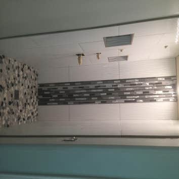 Photos from Cota Custom Tile Master bathroom custom shower 12"x36" ceramic tile with glass mosaic. The shower floor is riverstone. Custom niche inserts
