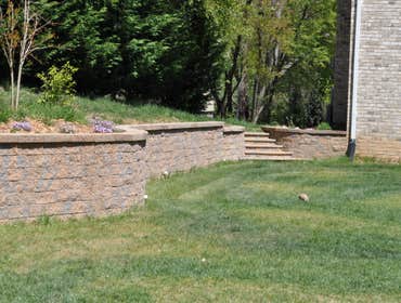 Retaining wall and drainage solution in Fulton, MD This retaining wall was over 100 ft. long! We also installed a drainage system so the previously slo