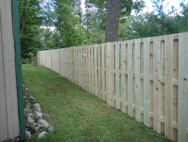 Minnewawa good neighbor fence. Treated wood good neighbor fence on property line.