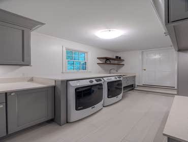 Gray Laundry Room Renovation Transform your laundry space with sleek, modern design! ?✨ From the custom cabinetry to the built-in seating area, this sp