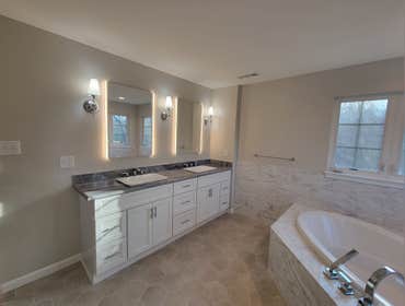 Photos by M&c Global Construction LLC #12 This Randallstown, MD, bathroom remodel transformed the space with a walk-in shower, custom vanity, and elega