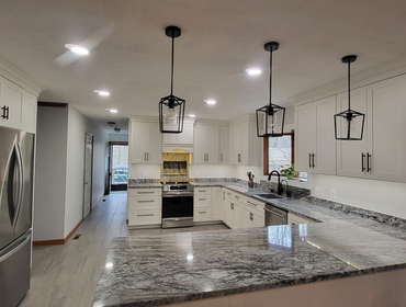 Bel Alton Kitchen Renovation This modern kitchen features an elegant design with custom white cabinetry and stunning granite countertops, creating a ti