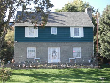 Stone House Remove cabinets and window, add wall closet to bedroom, install sliding door, tile on inside of slider, add secound story deck to front of 