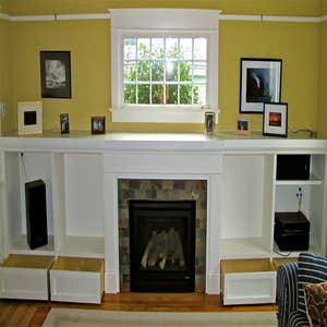 Shamburg Heating LLC Project Before and after a fireplace installation with mantle and cabinets.