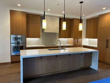 Clear Creek Tahoe kitchen Taj Mahal quartzite slab kitchen counters and range hood, including custom farm style stone sink apron. Vanity counters with