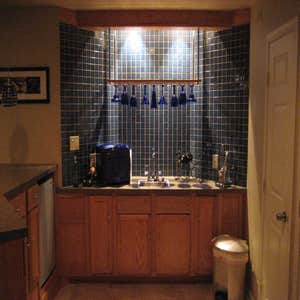 Finishing a Basement The client wanted three distinct areas in the basement - a home theater, a gym and a bar - along with a powder room. We...