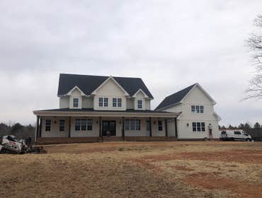 Exterior elevation showing modern farmhouse board-and-batten siding, wrap-around porch, and attached garage.
