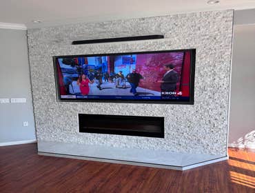 Antioch Electric Fireplace & Custom Entertainment center TV entertainment center with electric fireplace, natural stone wall and ceiling lights.