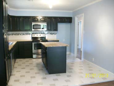Project photos from RTA Cabinet Store This kitchen features RTA Traditional Oak kitchen cabinets, white and gray veined ceramic tile and gray tile flo