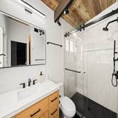 Bathroom Remodel We transformed this bathroom into a modern retreat featuring a double vanity with marble countertops, warm wood cabinetry, and luxurio