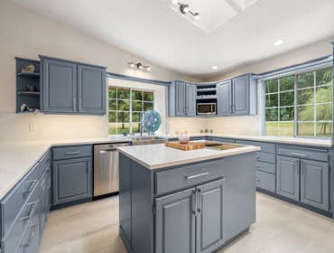 Callie | Kitchen This Snohomish kitchen remodel features a modern transformation with sleek blue cabinetry, quartz countertops, and a spacious center i