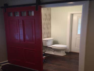 James Island Barn Door Slider Repurposed barn door slider painted in red and updated bathroom with rustic flooring and tile accent wall