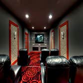 Red and Black Home Theater Converted storage space in the basement to a home theater with stadium seating and lobby area for treats and snacks.
