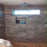 Eatonville Children's Bath Quality tile shower, very rich and stunning. Installed with 6in x 24in porcelain tiles in a darkened wood style. I would lik