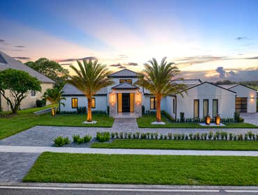 Custom Home Project "Brookline" This sprawling single-story home in Orlando opens to a high-ceiling living room anchored by a stone fireplace wall. A p