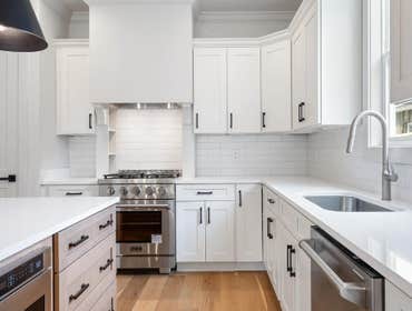 Crisp white shaker cabinetry with matte-black hardware and quartz surfaces at 2703 Bronte Ave, Nashville, built by CJMC Build.