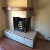 The Buskin A mid century modern fireplace with a custom oak mantel, large 18x18 and 12x24 porcelain tile from Pacific Tile, urethane grout and oil rubb