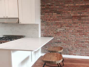 Upper West Side Our work for this project included full gut renovation with exposed brick wall, Calacatta countertop, and glass shower. Bathroom with c