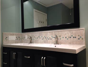 Vanity and tiled backsplash