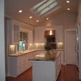 Great Room with Custom White Kitchen Full Home Remodel with Four Bearing Walls removed. A Level 5 smooth wall finish and a 44' vaulted ceiling and a co