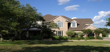 Photo(s) from Kelley Homes, Inc. Beautiful custom home with 1 acre lot on Hidden Oaks Golf Course. Stone and brick exterior with mature landscaping. 
