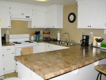 Camachos Custom Painting Project Drywall repair after kitchen backsplash removal. Cabinet refinishing for an updated design.
