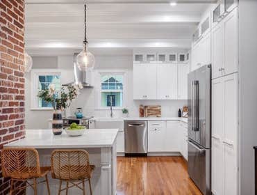 Photos by LCG BOSTON LLC #1 Full Home Remodel. Bathroom with custom glass, kitchen remodel with a beautiful exposed brick.