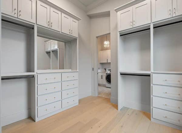 Custom primary closet with stacked cabinetry and laundry access designed by CJMC Build in 12 South, Nashville.