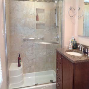 Farina - Bathroom This bathroom remodel included an acrylic pan with seat, 12 x 24 tile in a light cream and a decorative stone and glass border...