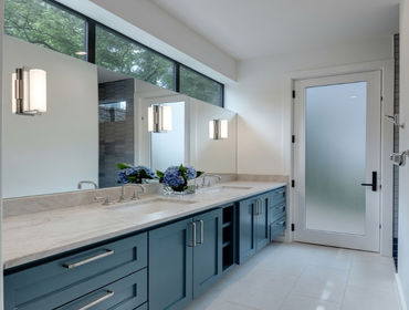 Bathroom Remodel This bathroom remodel features a bright, contemporary design with a custom double vanity, quartz countertops, oversized mirrors, and e