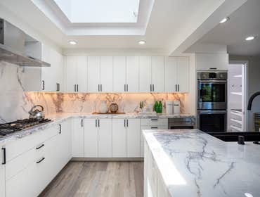 Kitchen Remodel Bright kitchen refresh making great use of the large space, tall ceilings, and light with a beautiful backsplash matching the counterto