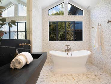 Luxury Bathroom Remodel The quiet luxury of this master bath is founded in its natural stone and solid brass fixtures. The vaulted ceilings add to a se