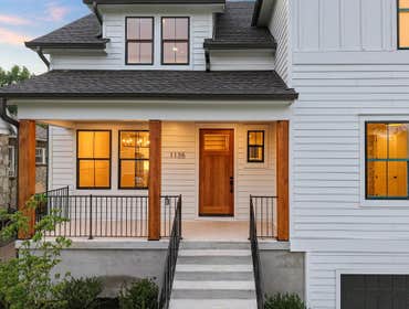 Welcoming front porch at 1135 Delmas Ave, East Nashville: warm wood door, black windows, and covered Porch modern farmhouse by CJMC Build.