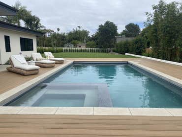 Photos by BP Water Concepts Inc #3 New pool and SPa with safety cover. IPE Wood deck and travertine coping. Finished in mini pebble.