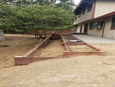 New concrete path and retaining wall with planter box area