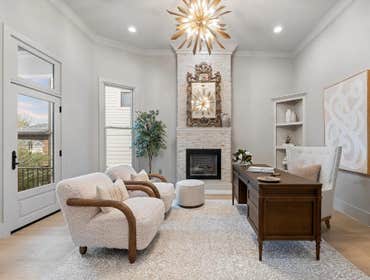 Parlor study with brick fireplace, ornate mirror, and patio door, renewed by CJMC Build in 12 South, Nashville.